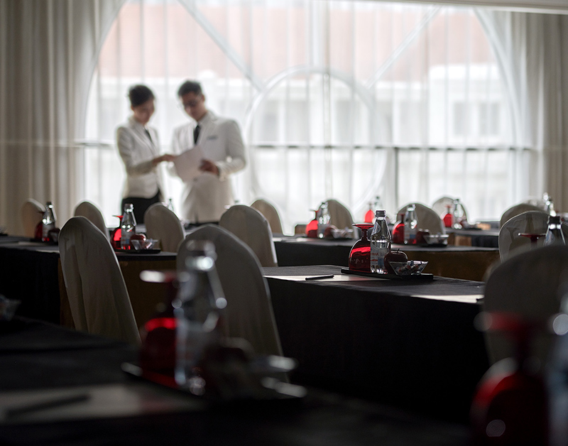 Two hotel management students discussing on the arrangement of the tables.