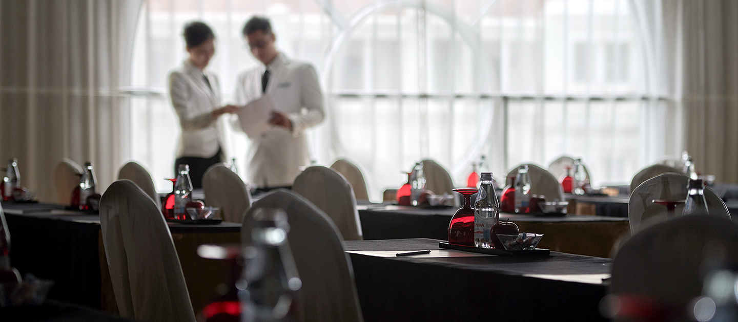 Two hotel management students discussing on the arrangement of the tables.